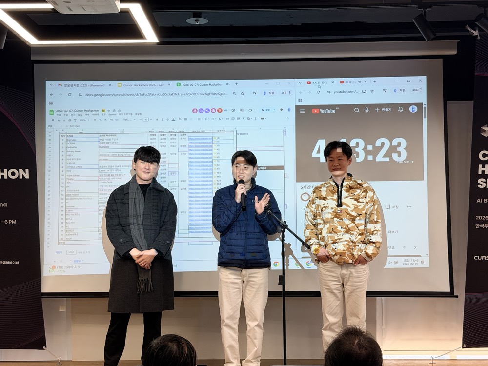 A team of three demoing on stage with the countdown clock behind them