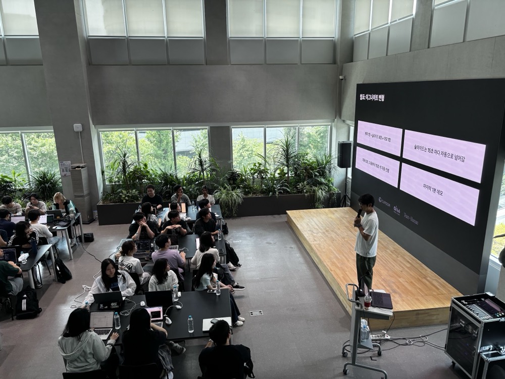 Briefing from the stage at Seoul AI Hub, Cursor and Team Human logos on the LED wall