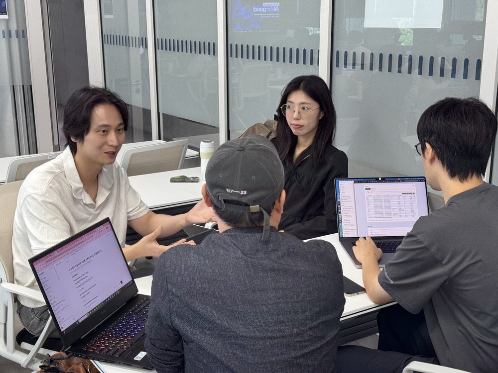 A four-person team huddle around laptops during the morning build